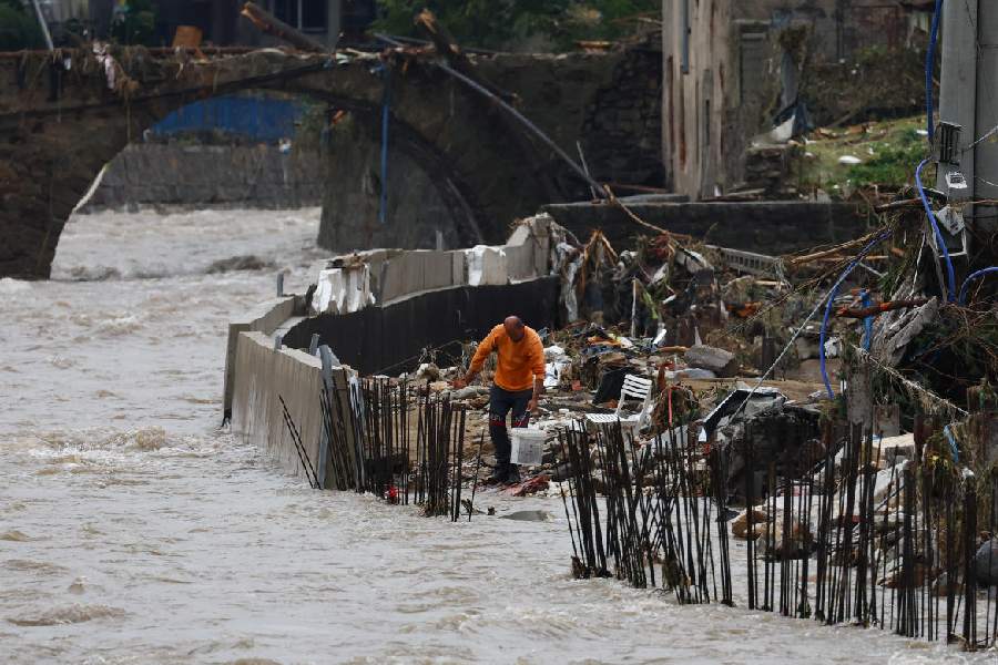 A man holds a bucket at destroyed banks during the aftermath of flooding by the Biala Ladecka River in Ladek Zdroj, Poland.