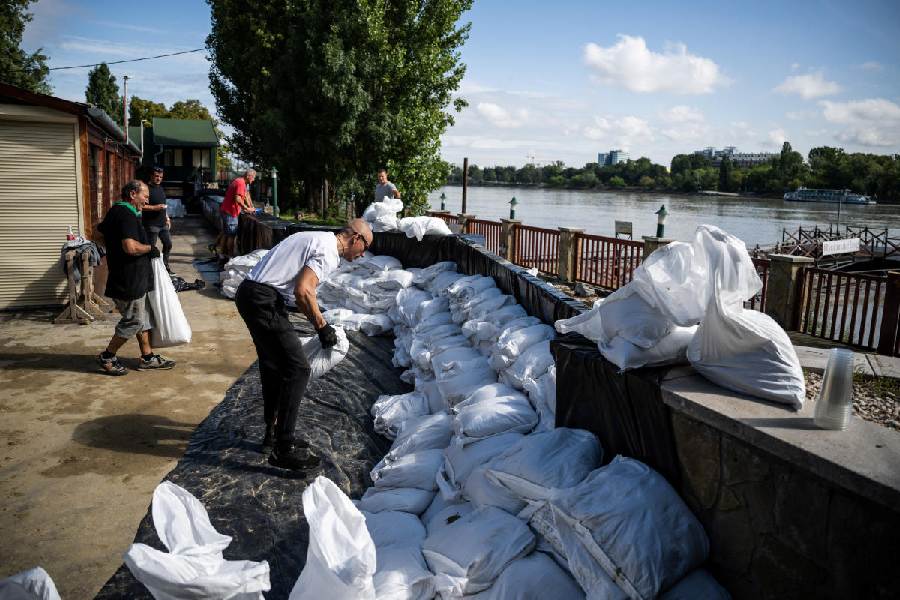 People make a sandbag dam to protect a family owned restaurant next to the river Danube in Budapest, Hungary, September 17, 2024.