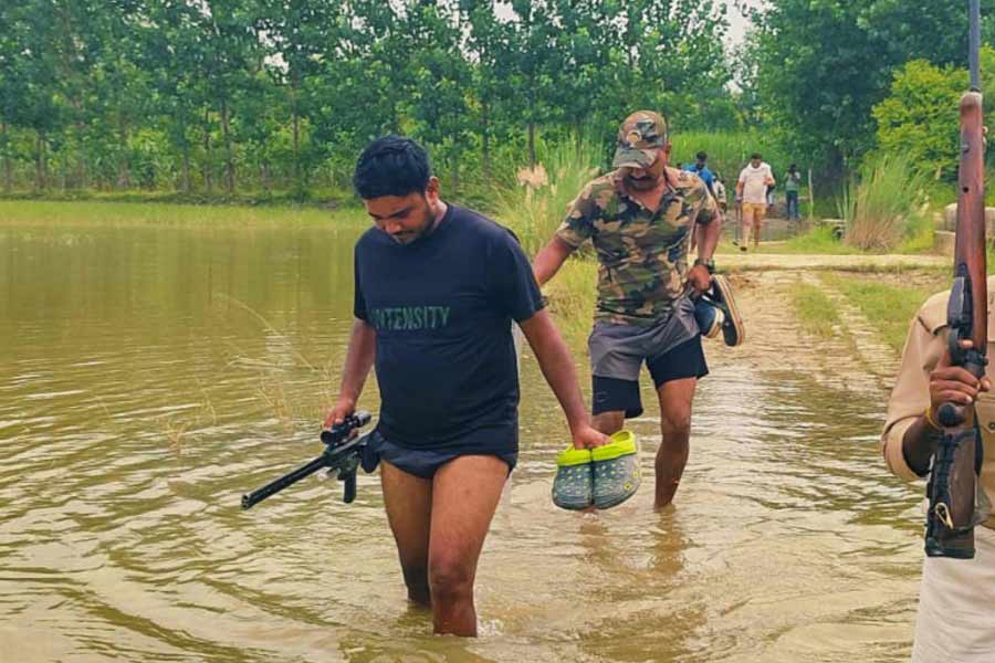 Shooters cross a river during the ‘Operation Bhediya’ at an area in Bahraich district