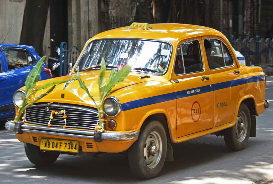 Banana plants and marigold garlands adorn an iconic yellow Kolkata taxi for Vishwakarma Puja on Tuesday