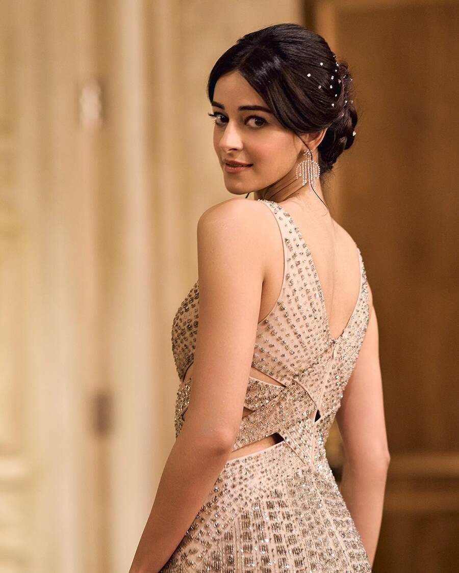 In the throwback scene of her debut as a Delhi socialite at a Parisian gala, Ananya’s Bae dazzles in a beige sequined gown with side cut-outs, designed by Rohit Gandhi & Rahul Khanna. Dewy makeup, drop earrings from Vandals and a braided bun completed her look, capturing the picture-perfect lifestyle Bae once had.