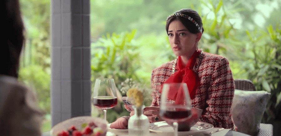 A red-and-peach tweed jacket and a matching mini skirt with a red scarf and a gemstone-studded headband make up Bae’s business casual look, which too reflects Emily’s love for vibrant outerwear in Emily in Paris. 