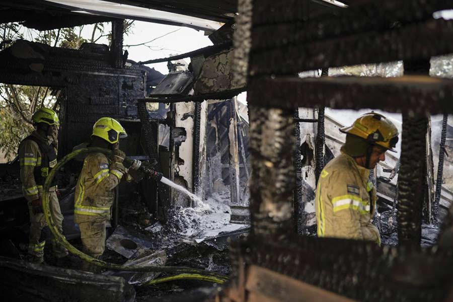 Israeli firefighters work at a house that was hit by a rocket fired from Lebanon, near the city of Safed, northern Israel, on Sept. 21, 2024. 