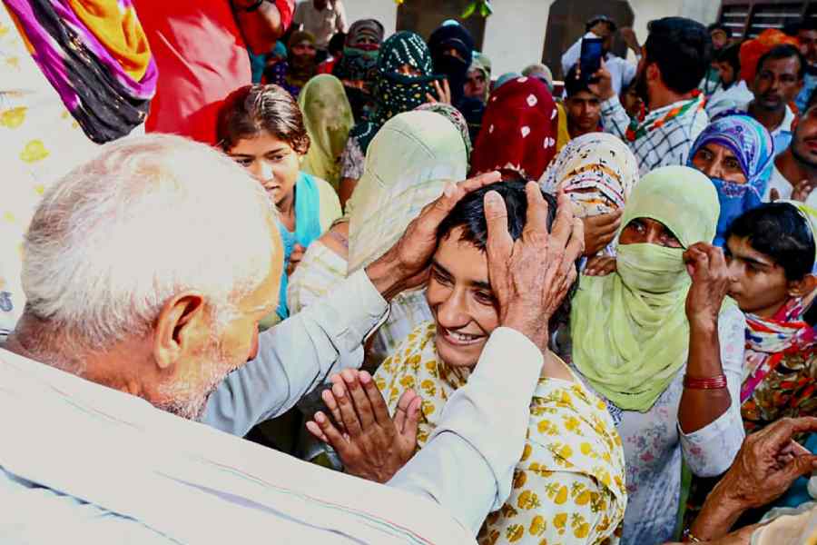 Vinesh Phogat interacts with a villager while campaigning at Siwaha village in Jind, Haryana.