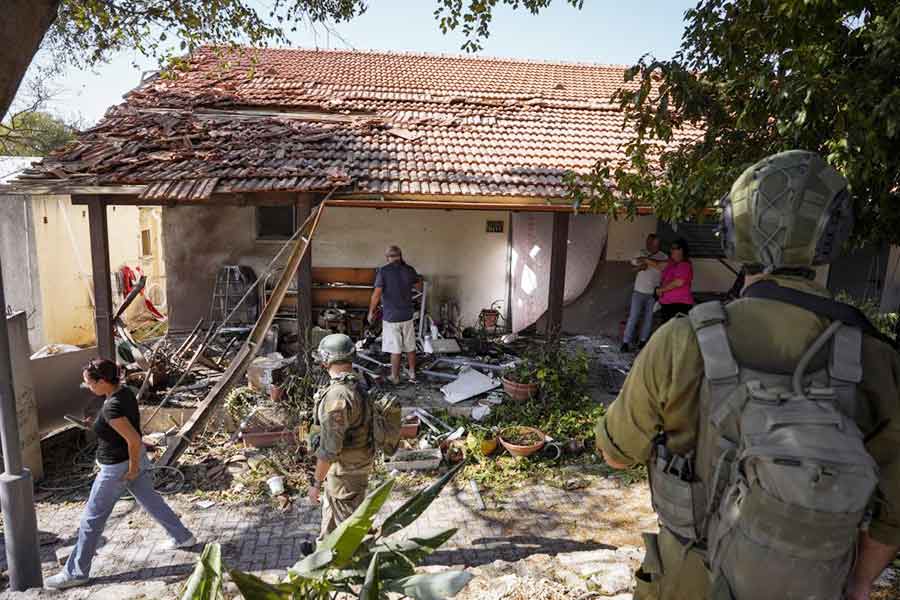 Israeli security forces and residents examine a house that was hit by a rocket fired from Lebanon, in Kibbutz Saar, northern Israel, on Sept. 25, 2024. 