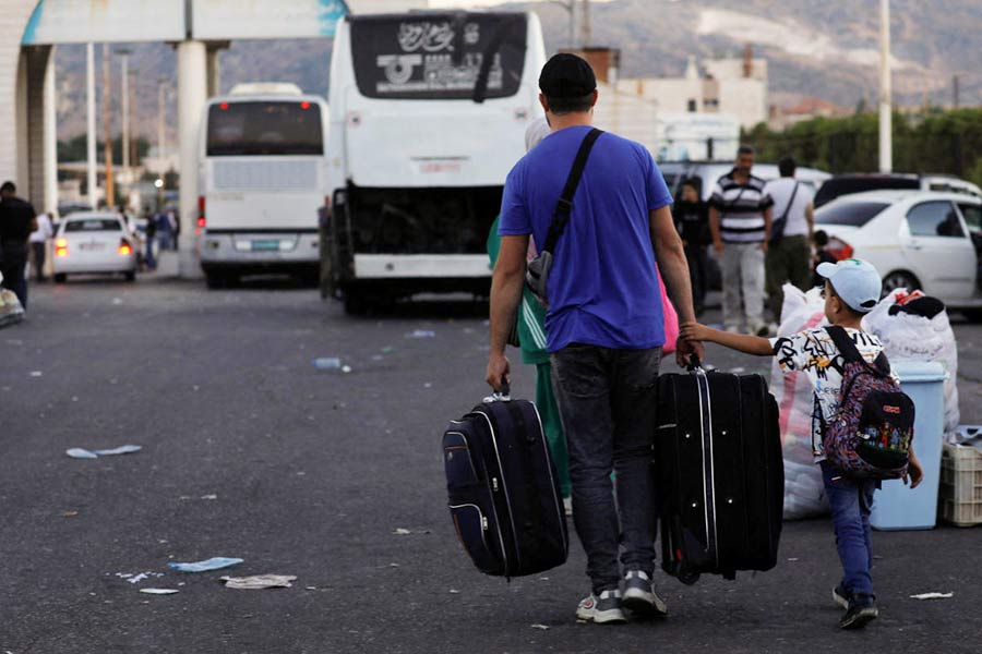 Syrians, who were living in Lebanon and returned to Syria due to ongoing hostilities between Hezbollah and Israeli forces, carry belongings at the Syrian-Lebanese border, in Jdaydet Yabous, Syria, September 25, 2024. 