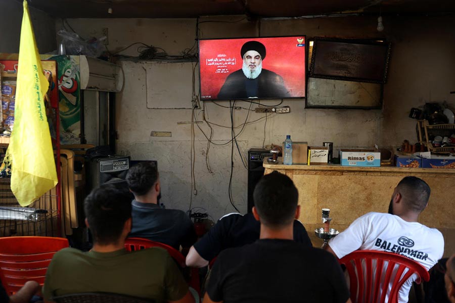 People watch Sayyed Hassan Nasrallah delivering a televised address, as they sit at a cafe in Sidon, Lebanon on September 19, 2024.