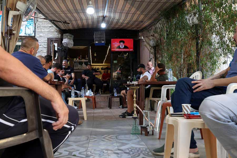 People watch Lebanon's Hezbollah leader Nasrallah delivering a televised address, as they sit at a cafe in Beirut, Lebanon on September 19, 2024.