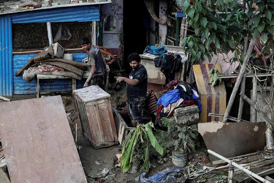 People salvage their belongings at a house that was submerged in water after the floodwater recedes in an area that was flooded by the overflowing Bagmati River following heavy rains, in Kathmandu