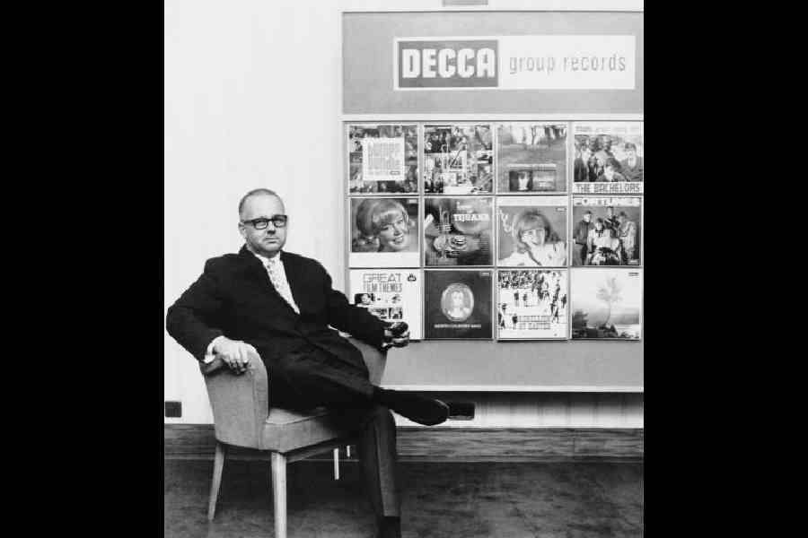 Decca Records producer and A&R man Dick Rowe. Behind him is a display of Decca albums by Lulu, The Bachelors and others. Picture: Getty Images