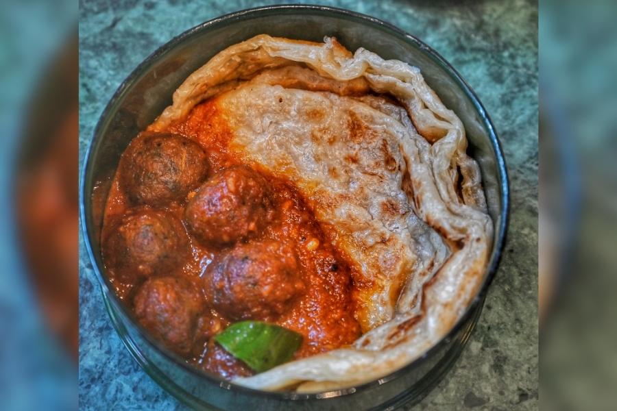 The first box opens to a crunchy hand-tossed broad beans with a fried tofu sandwich, followed by (above) the mock meatball curry with flaky palata