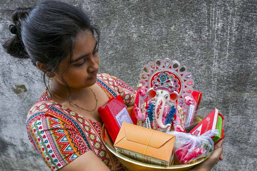 A woman carries an idol of Lord Ganesh amid Bengali New Year celebrations, in Nadia.