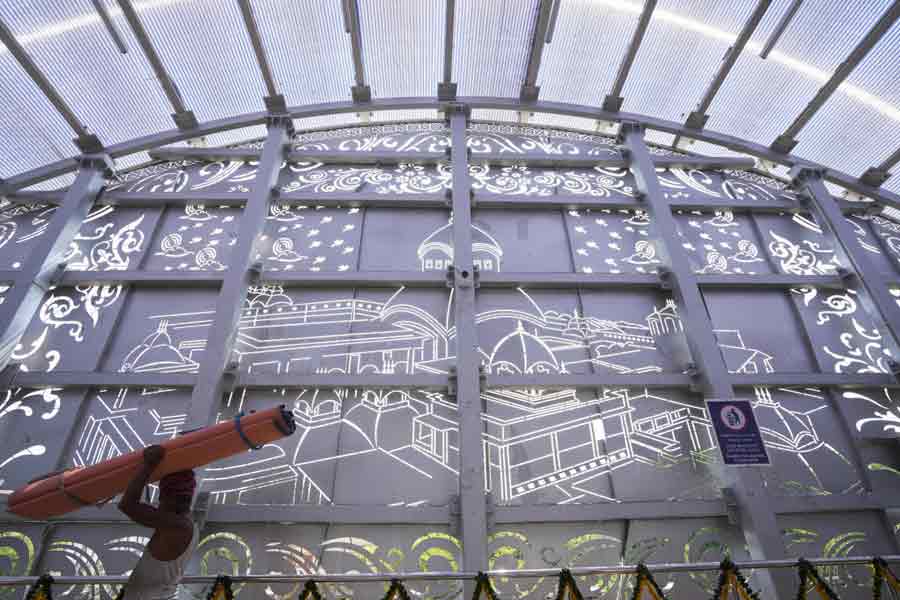 A worker walks past Kalighat's skywalk wall depicting artwork, amid Bengali new year celebrations, in Kolkata.