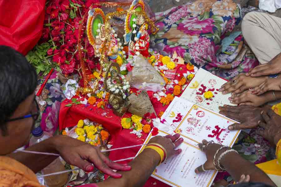 People offer prayers as a trader's account book is seen marked with holy symbols on 'Poila Boisakh' or Bengali New Year's day, in Kolkata.