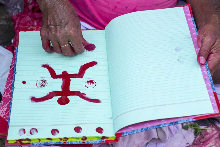 A woman marks a trader's account book with holy symbols on 'Poila Boisakh' or Bengali New Year's day, in Kolkata.