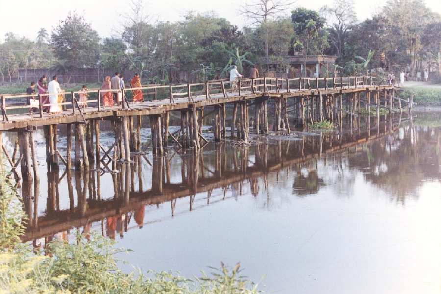 A file picture of people crossing a wooden bridge over Noukhal, a branch of the Bidyadhari at Langolpota, Rajarhat. This is where the river had bifurcated and one arm had entered Salt Lake. That arm has silted up now