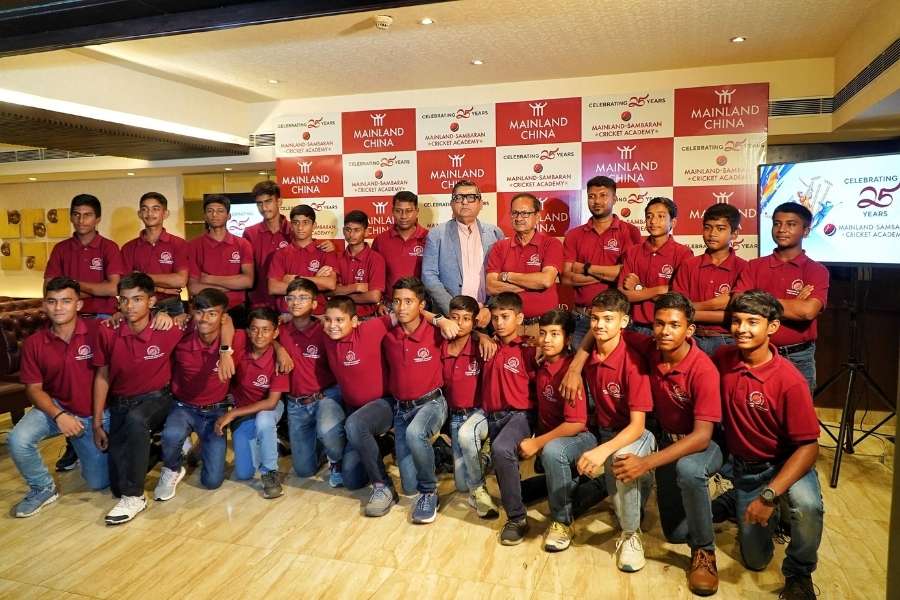 Sambaran Banerjee and Anjan Chatterjee pose with young cricketers from the academy