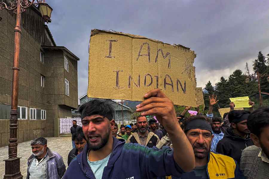 A Srinagar trader on Wednesday holds up a poster calling for the killing of innocents to stop.