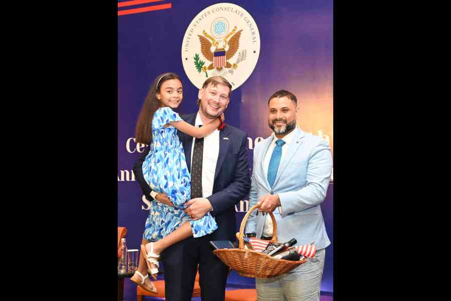 US consul hands over a gift hamper to the winner of a quiz on the US