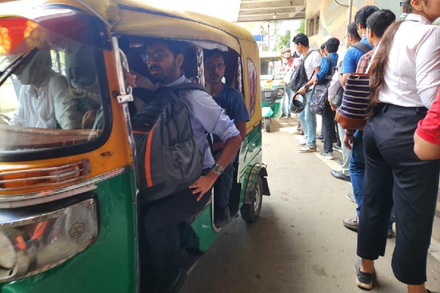 Passengers cram into an auto while others wait in the queue to head to the New Town bus terminus on Tuesday