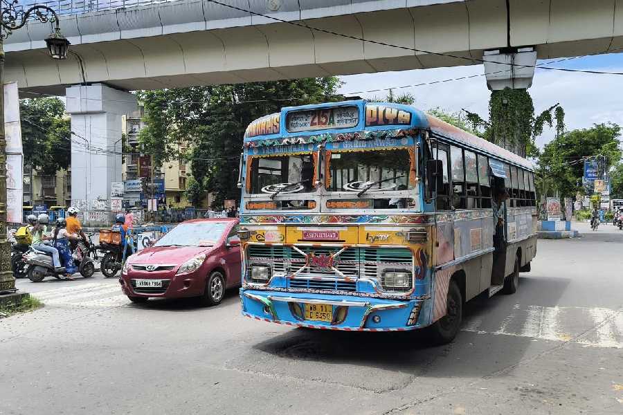 An empty 215A bus under the Metro viaduct at Karunamoyee. The bus owners are hopeful of no major impact of the Metro route expansion.
