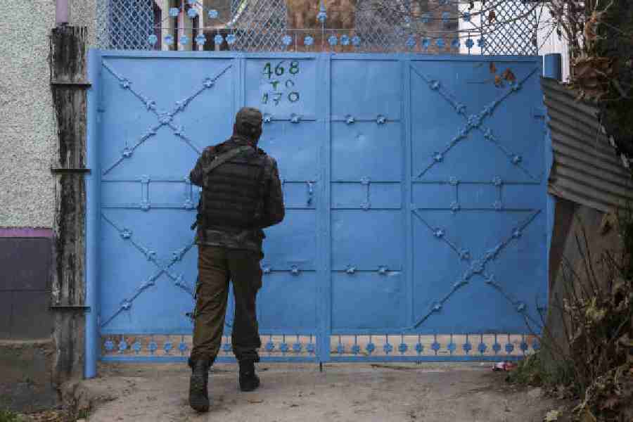 A security official at a house in Pulwama during a raid in connection with the Red Fort blast probe on Monday.