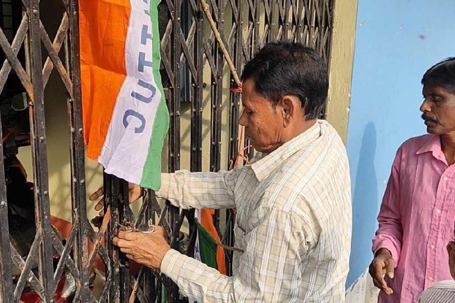A contractual employee locks the office of the water resources investigation and development department in Balurghat  on Monday