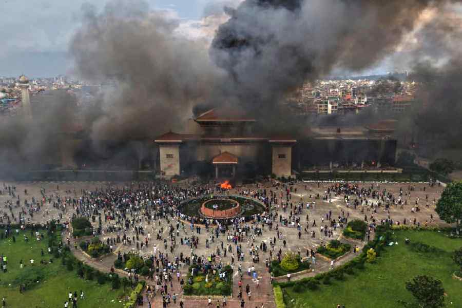 Protesters celebrate at the Singha Durbar, the seat of Nepal's government's various ministries and offices after it was set on fire during a protest against social media ban and corruption in Kathmandu