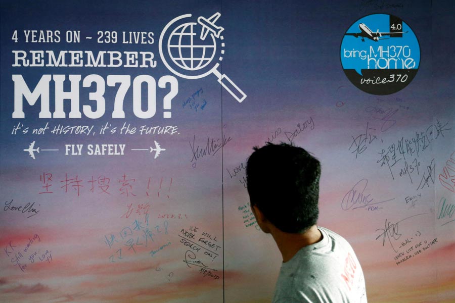 FILE PHOTO: Man looks at message board for passengers onboard missing MH370 in Kuala Lumpur
