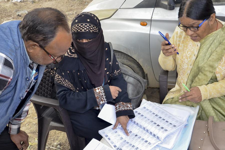 Booth-Level Officers (BLO) assist a voter in filling out forms for the Special Intensive Revision (SIR) of electoral rolls, in Mirzapur, Uttar Pradesh, Nov. 27, 2025.