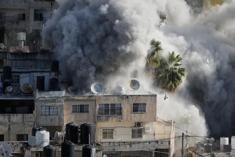 Smoke rises as Israeli forces demolish the home of Abdul Karim Sanoubar, a suspected Palestinian militant who has been accused by Israel of planting bombs on buses in central Israel, in Nablus, West Bank, Tuesday, Dec. 2, 2025.