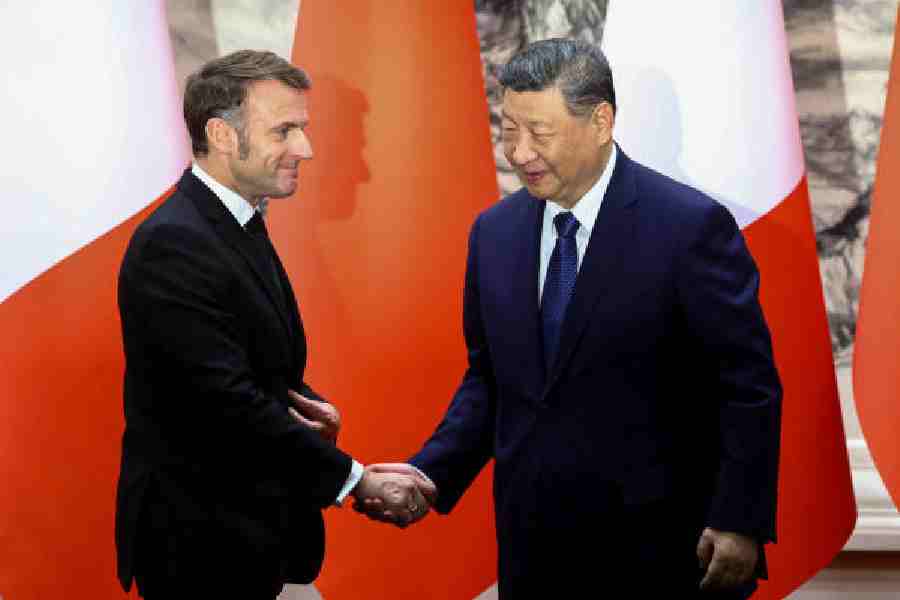 Emmanuel Macron (left) and Xi Jinping shake hands in Beijing on Thursday.
