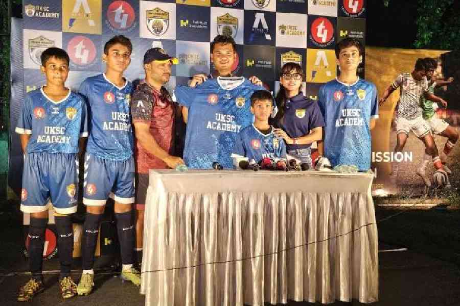 The academy jersey being unveiled by head coach Yan Law, flanked by women's team head coach Prasanta Bhattacharya and women's team captain Puja Karmakar, during the UKSC Football Academy inauguration at GD Park on Saturday