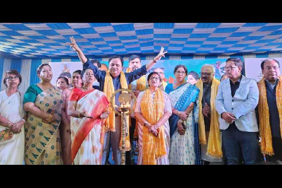 The dignitaries sing along in chorus after lighting the ceremonial lamp at the fair inauguration on Monday.