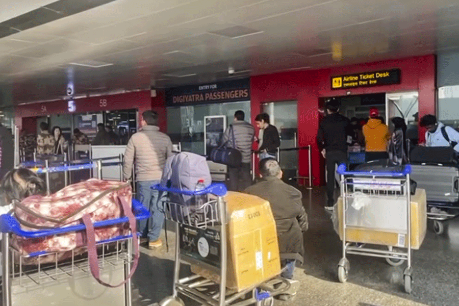Stranded passengers stand in a queue after IndiGo cancelled more than 400 flights, at the Indira Gandhi International (IGI) Airport, in New Delhi, Friday, Dec. 5, 2025.