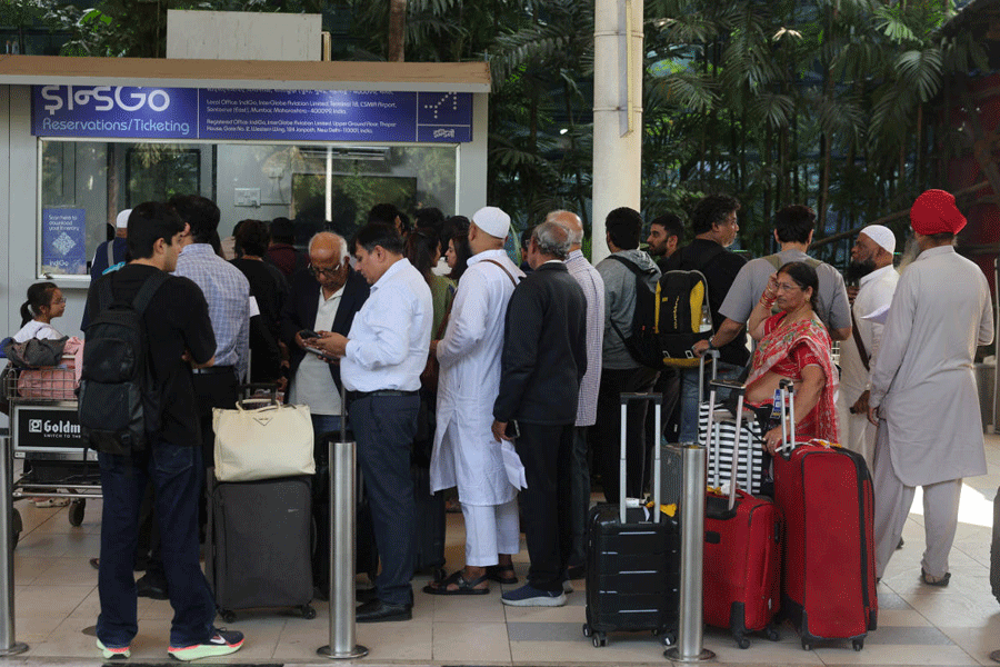 Passengers wait outside the IndiGo airlines ticket counter after several flights were cancelled at Mumbai Airport Terminal-1, in Mumbai, India, December 5, 2025.