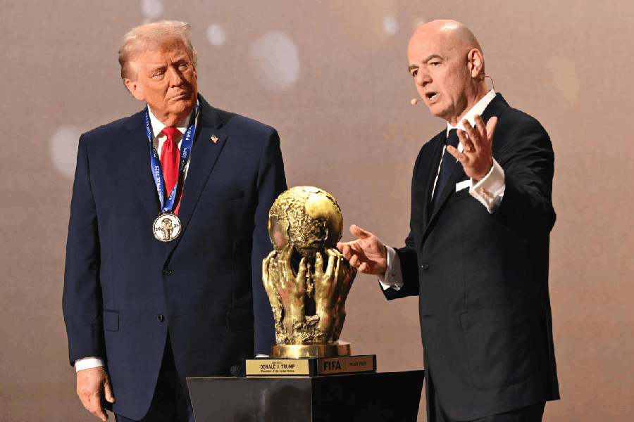 President Donald Trump looks on as FIFA President Gianni Infantino presents him with the FIFA Peace Prize during the draw for the 2026 soccer World Cup at the Kennedy Center in Washington, Friday, Dec. 5, 2025.