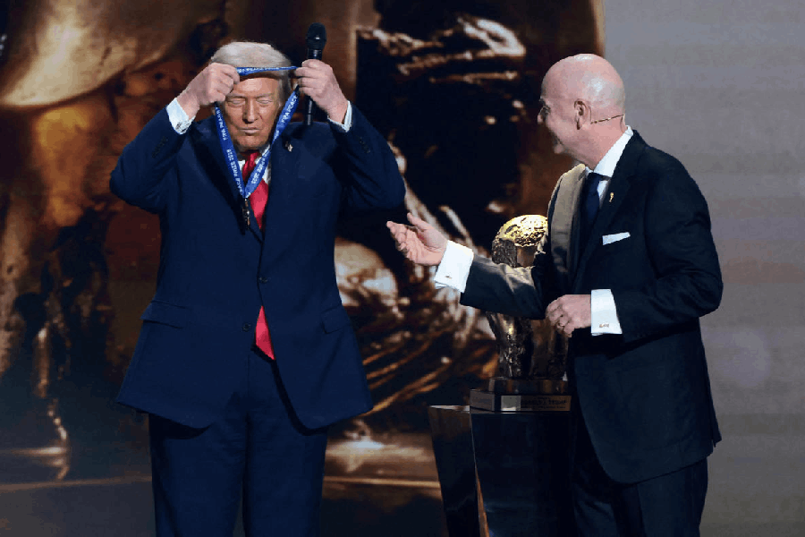 US President Donald Trump wears a medal as he is awarded the inaugural FIFA Peace Prize by FIFA President Gianni Infantino during the FIFA World Cup 2026 Draw.