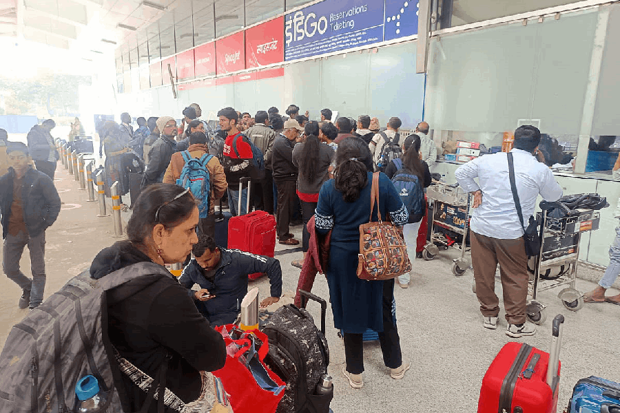 Passengers gather near an IndiGo airlines counter amid flight disruptions, at Lal Bahadur Shastri International Airport, in Varanasi, Saturday, Dec. 6, 2025.