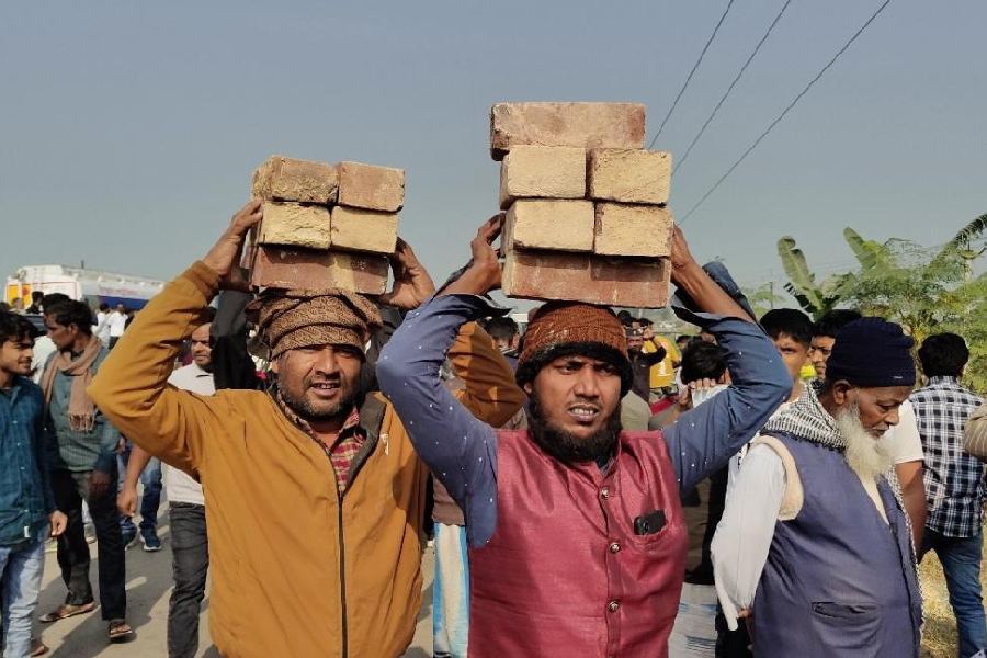 People carry bricks to donate for the construction of the proposed Babri mosque in Murshidabad on Saturday.
