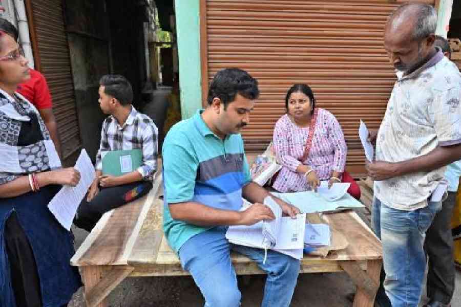 A BLO distributes enumeration forms for the SIR to residents of Rampurhat in Birbhum district