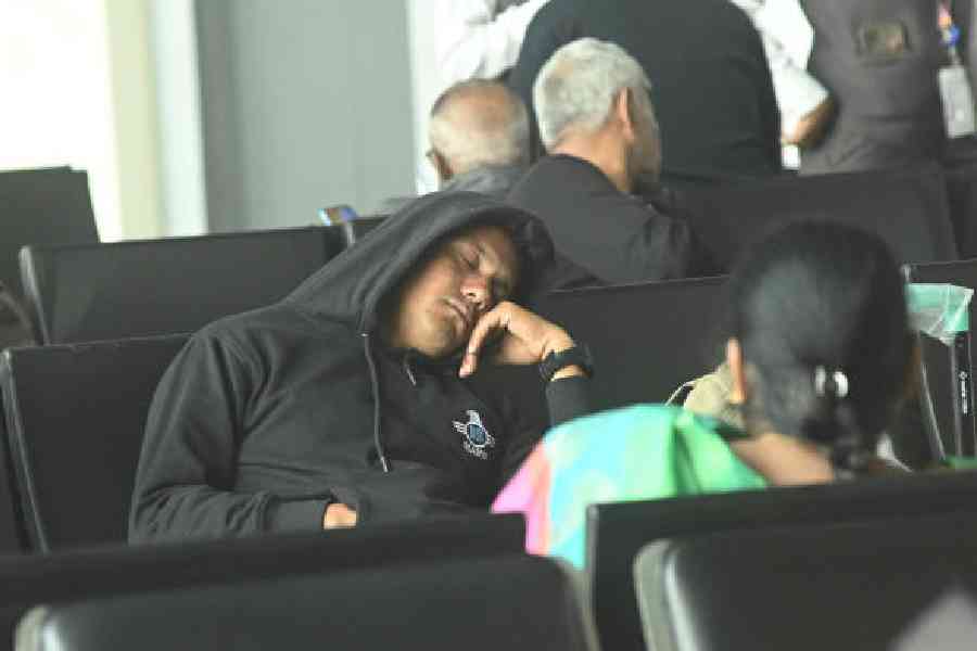 A passenger takes a nap at the Calcutta airport on Sunday afternoon. Picture by Bishwarup Dutta