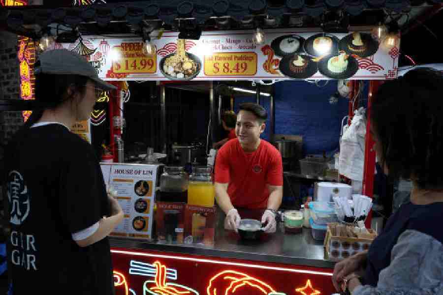 Dimi Heryxlim, 15, a social media content creator, serves customers at his food stall at Burwood Chinatown in Sydney on November 14.