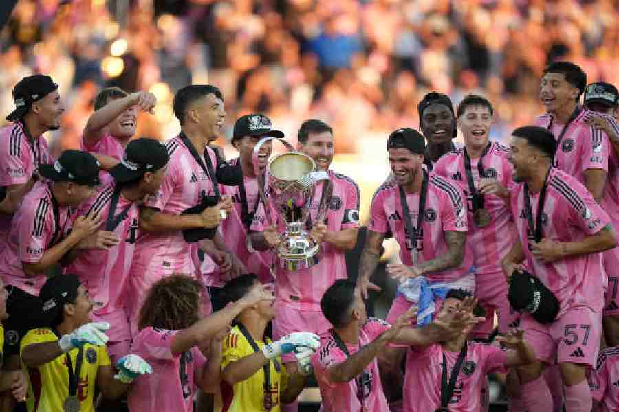 Inter Miami’s Lionel Messi (with trophy) celebrates with teammates after defeating Vancouver Whitecaps 3-1 to win the MLS Cup in Fort Lauderdale on Saturday. 