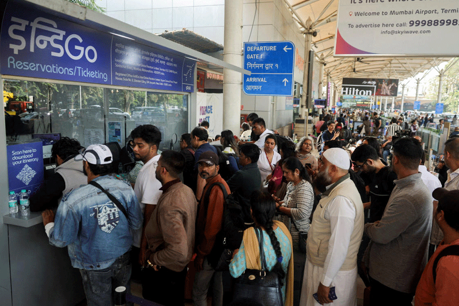 FILE PHOTO: Passengers wait outside the IndiGo airlines ticketing counter at the Chhatrapati Shivaji Maharaj International Airport, after several IndiGo airlines flights were cancelled, in Mumbai, India, December 6, 2025.