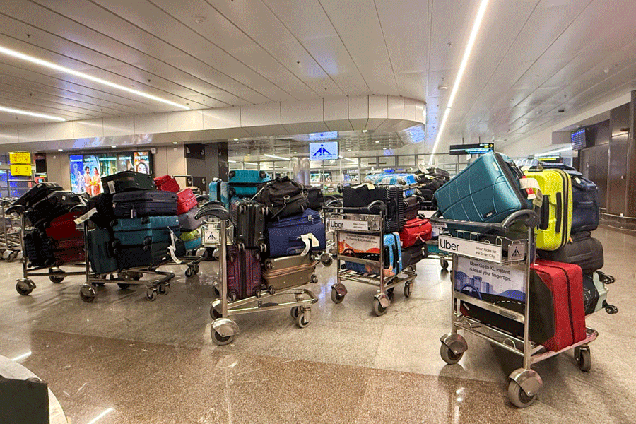 FILE PHOTO: Luggage of passengers whose IndiGo flight was cancelled sits on trolleys at an airport in Pune