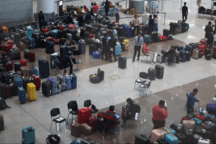 Staff members of IndiGo tag stranded bags and belongings of IndiGo passengers following large-scale flight disruptions, at Terminal 1 of Indira Gandhi International Airport in New Delhi, India, December 8, 2025.