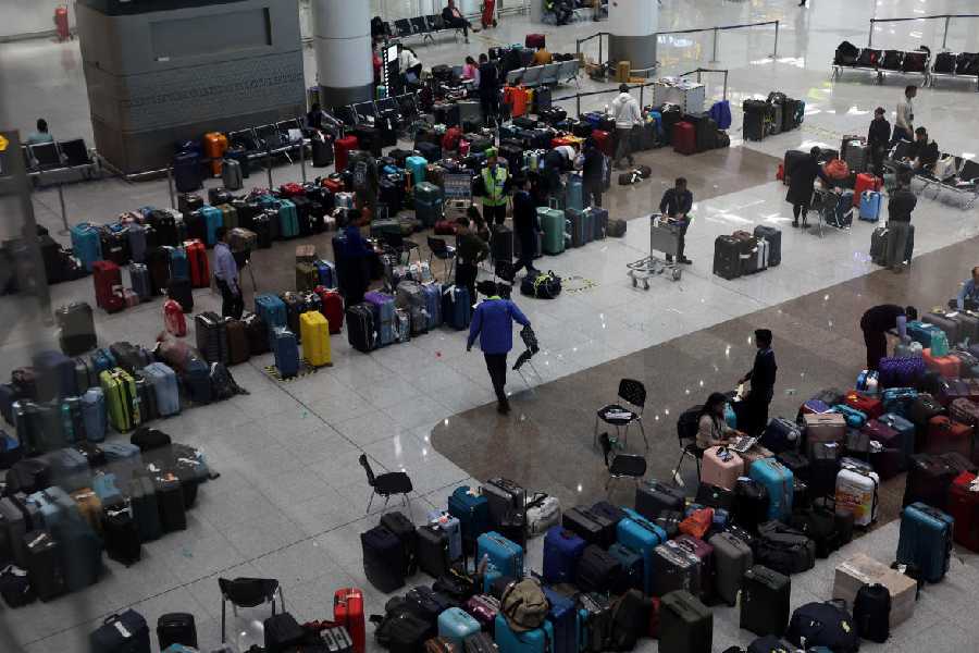 Staff members of IndiGo tag stranded bags and belongings of IndiGo passengers following large-scale flight disruptions, at Terminal 1 of Indira Gandhi International Airport in New Delhi, India, December 8, 2025.