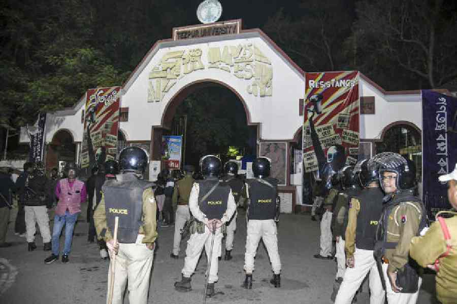Policemen stand guard as students block the exit during a protest against alleged irregularities by VC Shambhu Nath Singh at Tezpur University, Assam, on Sunday. 