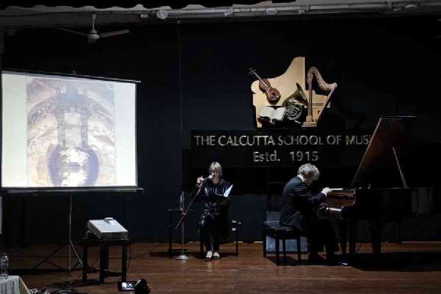Rokas Zubovas plays a piece by Mikalojus Čiurlionis on the piano with Sonata Zubovas on the mic as a painting on a similar theme by the Lithuanian composer is shown on screen at Calcutta School of Music